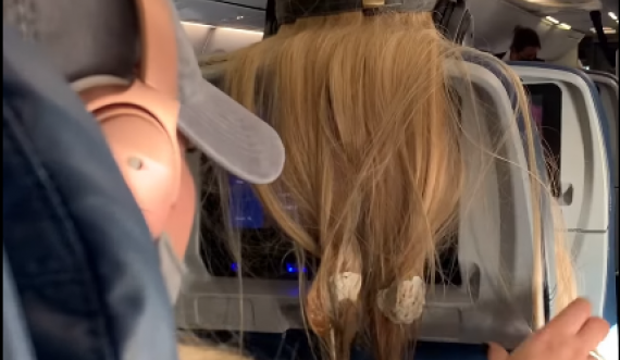 Biondina hidhte flokët prapa ulëses në aeroplan, pasagjerja ia pret ato dhe ia lidh me çamçakëz