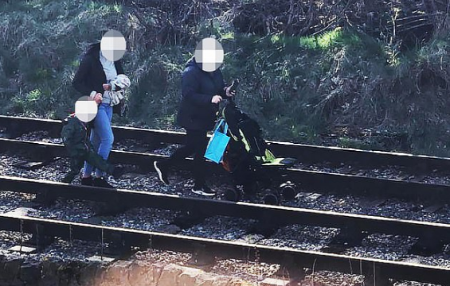 Dy gra shihen duke ecur me fëmijë e karrocë në hekurudhë 