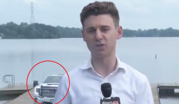 Gazetari raporton drejtpërdrejt, vetura prapa tij rrëshqet në liqen 