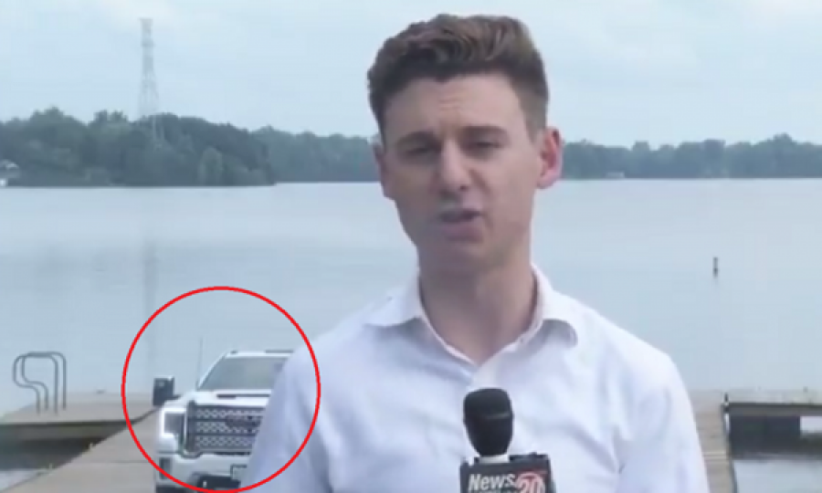 Gazetari raporton drejtpërdrejt, vetura prapa tij rrëshqet në liqen 