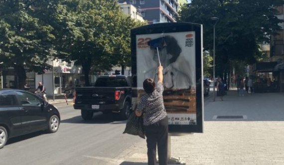  Një grua në Tiranë pastron reklamën e shkarravitur ku është fshirë fytyra e Goran Bregoviqit 
