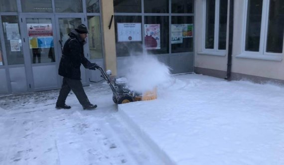  Mërgimtari heq borën nga oborri i qendrës së votimit