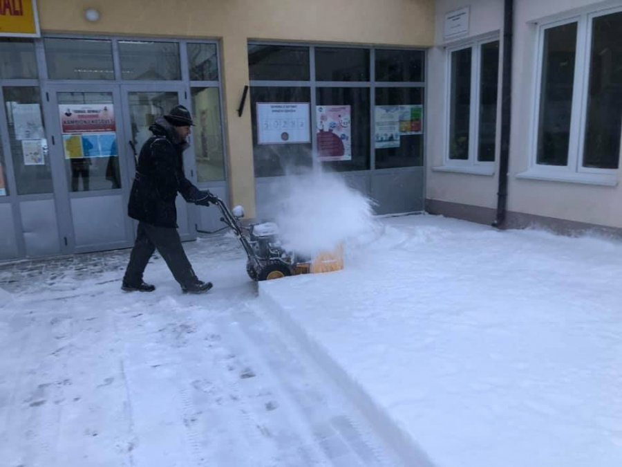  Mërgimtari heq borën nga oborri i qendrës së votimit