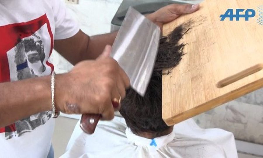 Berberi që ofron prerje flokësh me zjarr dhe hanxhar 