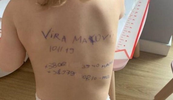 Nëna ukrainase shkruan emrin e vajzës dhe numrin e telefonit mbi shpinën e zhveshur