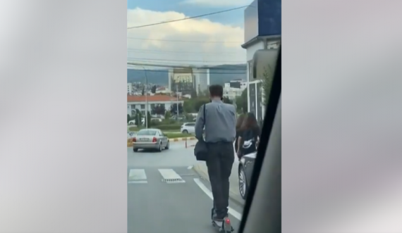 Qytetari në Prishtinë njërën dorë në telefon, tjetrën në trotinet