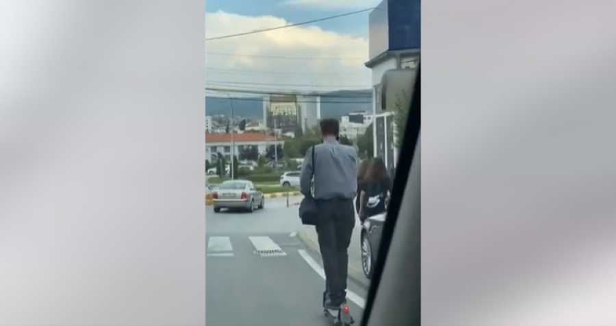 Qytetari në Prishtinë njërën dorë në telefon, tjetrën në trotinet