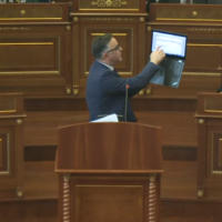 Besnik Tahiri del me laptop në foltore për ta shpjeguar rritjen e çmimit të rrymës