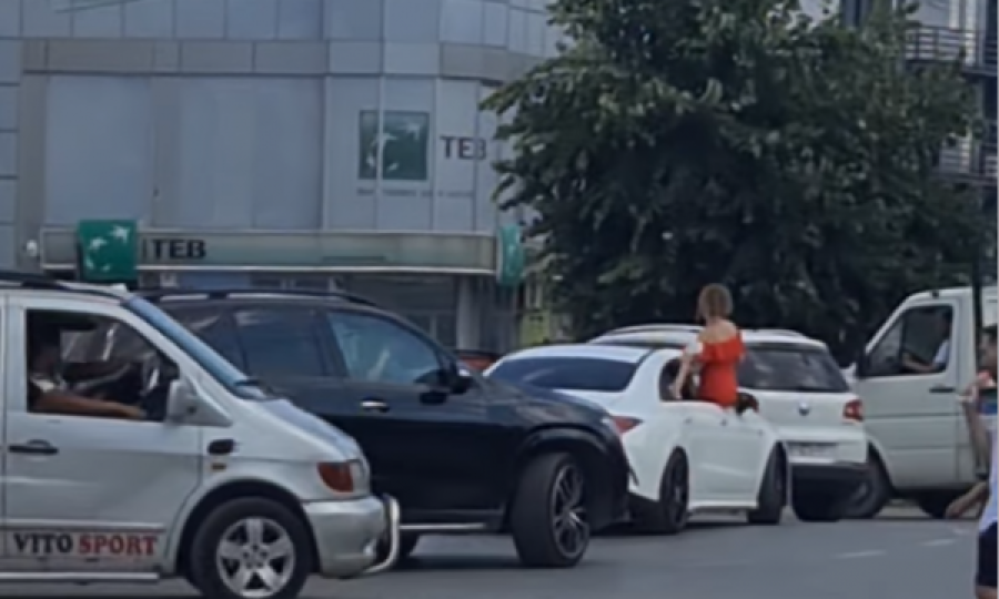 Dasma e rrezikshme, vajza rri ulur në derën e veturës