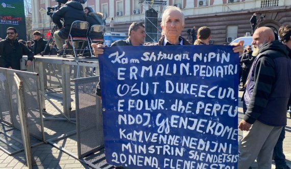  Qytetari merr pjesë në protestën e opozitës dhe tregon problemin e nipit të tij, ja pankarta që mban në duar