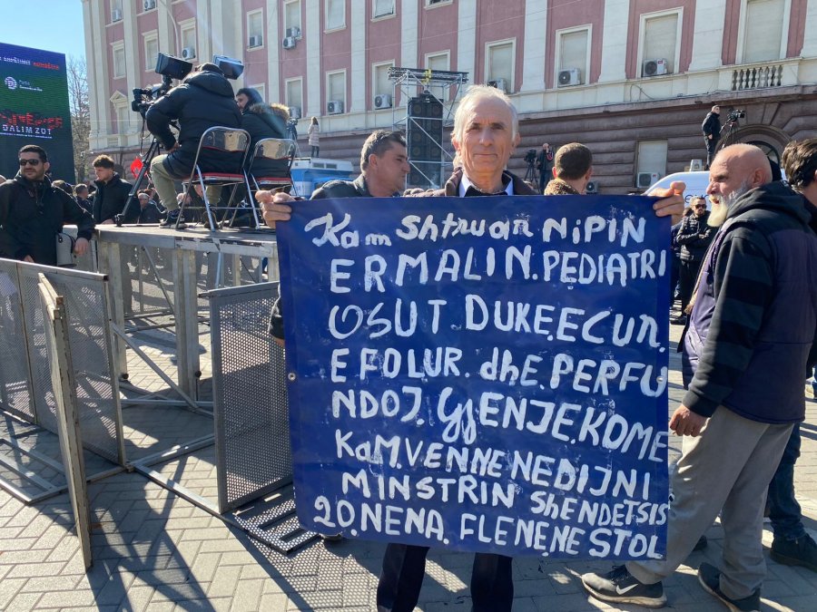 Qytetari merr pjesë në protestën e opozitës dhe tregon problemin e nipit të tij, ja pankarta që mban në duar