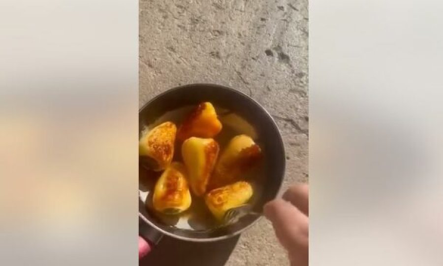 Temperaturat e larta në Kosovë: Një qytetar nga Prishtina fërgon specat në tigan në beton