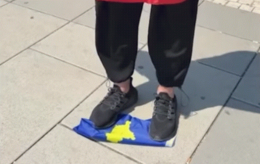 Një person vjen midis Prishtine dhe e përdhos flamurin e Kosovës 
